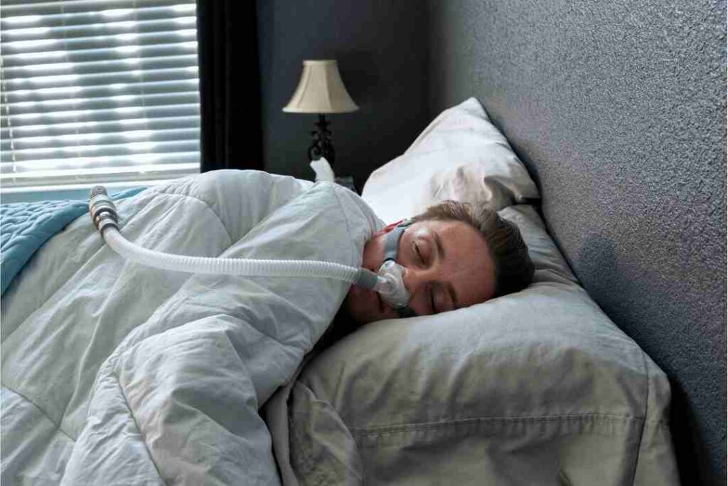 man-sleeping-with-a-cpap-machine-on-bed